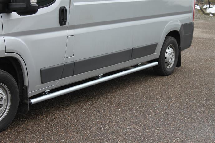 4020016_2_Sidebars_Galv_2.jpeg Gray van with a silver tubular side step running along the lower body, parked on a paved surface