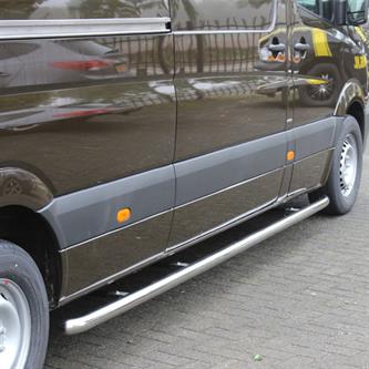 4020042_3_Sidebar-Blank_2.jpeg Dark brown van with chrome running boards along the lower side, orange side marker light, and wheel on a paved surface.